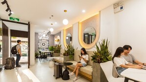 A modern hotel lobby with seating areas, a reception desk, and a decorative wall. - Crescendo Boutique Studio  (Hanoi)