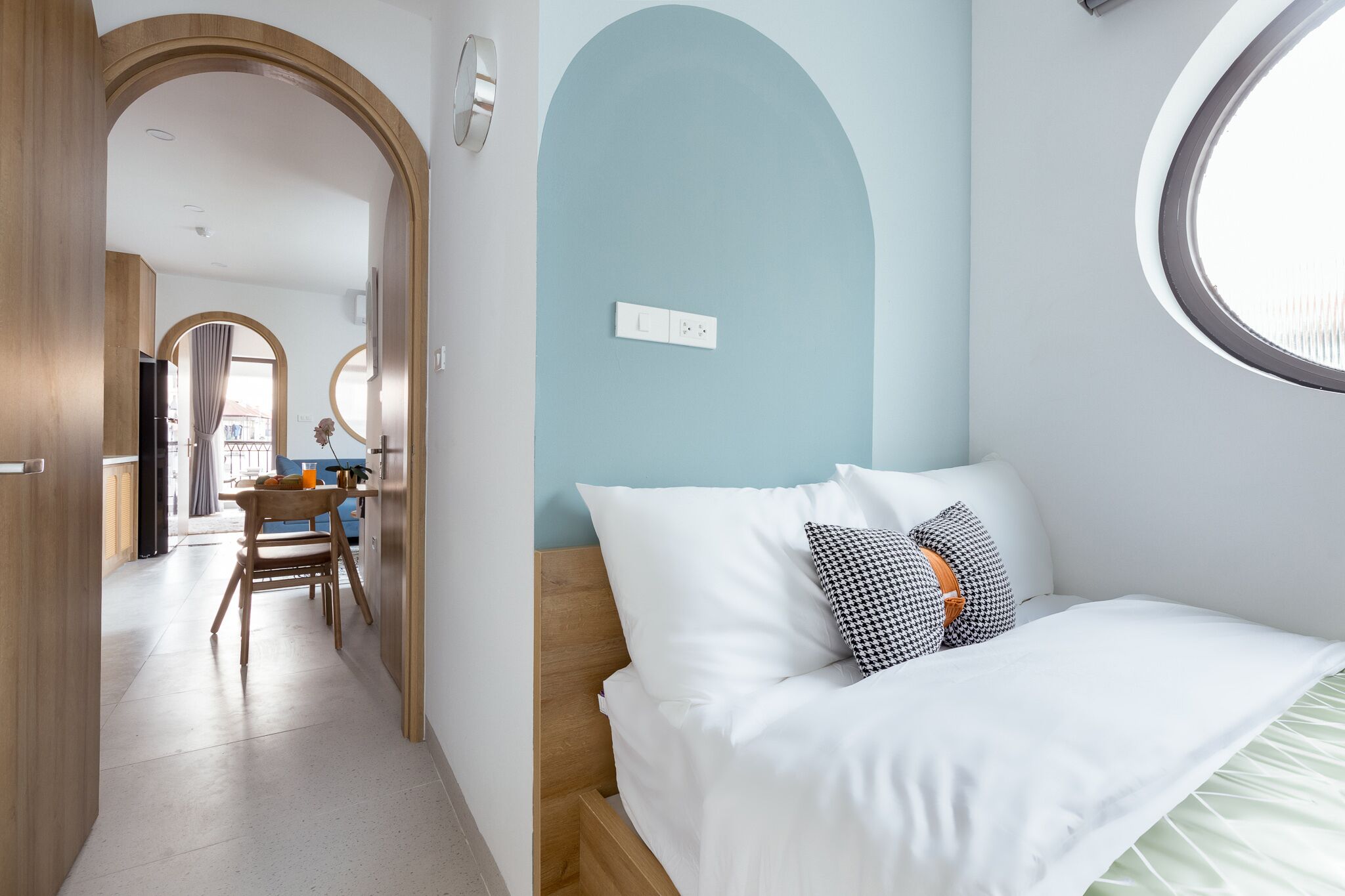 A bedroom with a bed, a window, and a view of the room's interior.