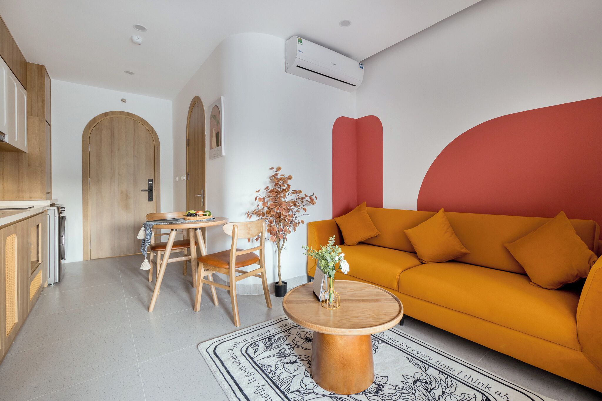 A modern living room with a sofa, a dining table, chairs, and a coffee table.