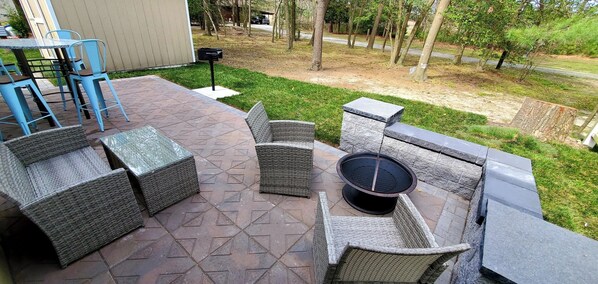 An outdoor patio with wicker furniture, a fire pit, and a mailbox. - 2 Bedroom Home Located in Lewes (Lewes)