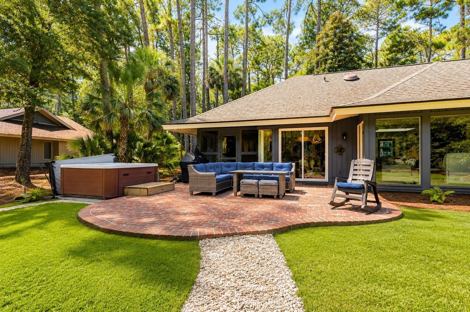 A patio with a hot tub, outdoor seating, and a covered area.