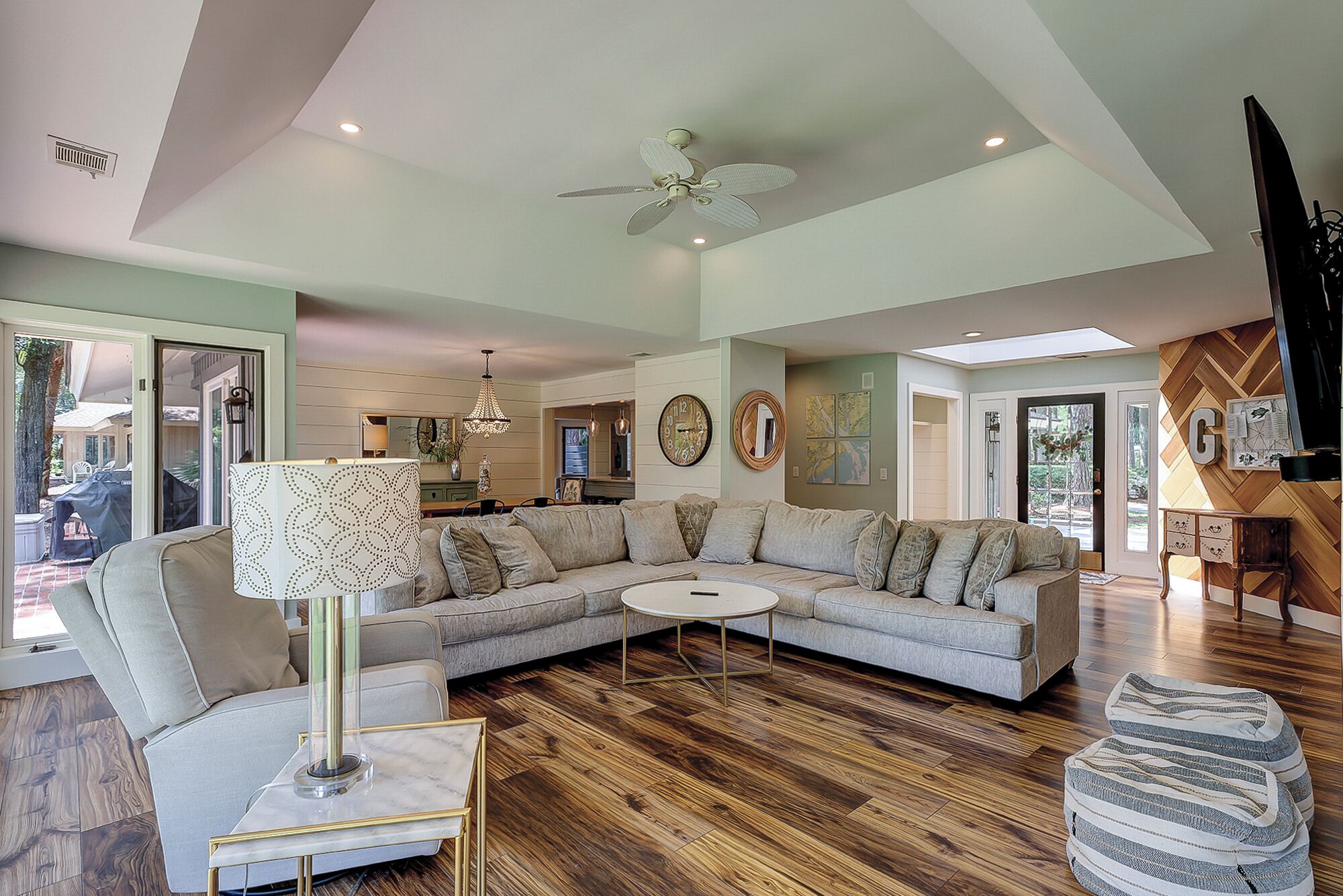 A spacious living room with a large sectional sofa, a round coffee table, and a floor lamp.