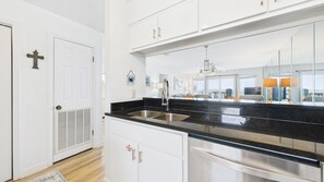 Kitchen features a large window, stainless steel appliances, and white cabinetry.