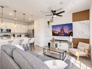 Un salon moderne avec un canapé, une table basse et un téléviseur.