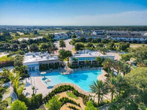 Un resort con una gran piscina, varias edificaciones y exuberante jardinería.