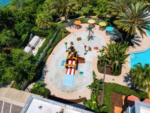 Vista aérea de um resort com piscina, palmeiras e área de recreação com tema pirata.