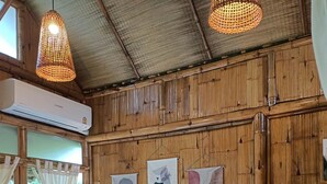 Una habitació amb un llit, dues làmpades penjades a la paret i tres obres d'art abstractes.