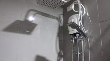 A shower with a handheld showerhead, a wall-mounted control panel, and a flexible hose.