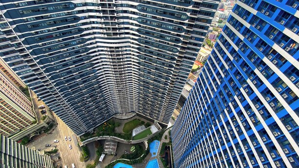 A high-rise building with a curved facade, multiple balconies, and a central courtyard with a swimming pool. - SMDC Air Residences Makati (Makati)