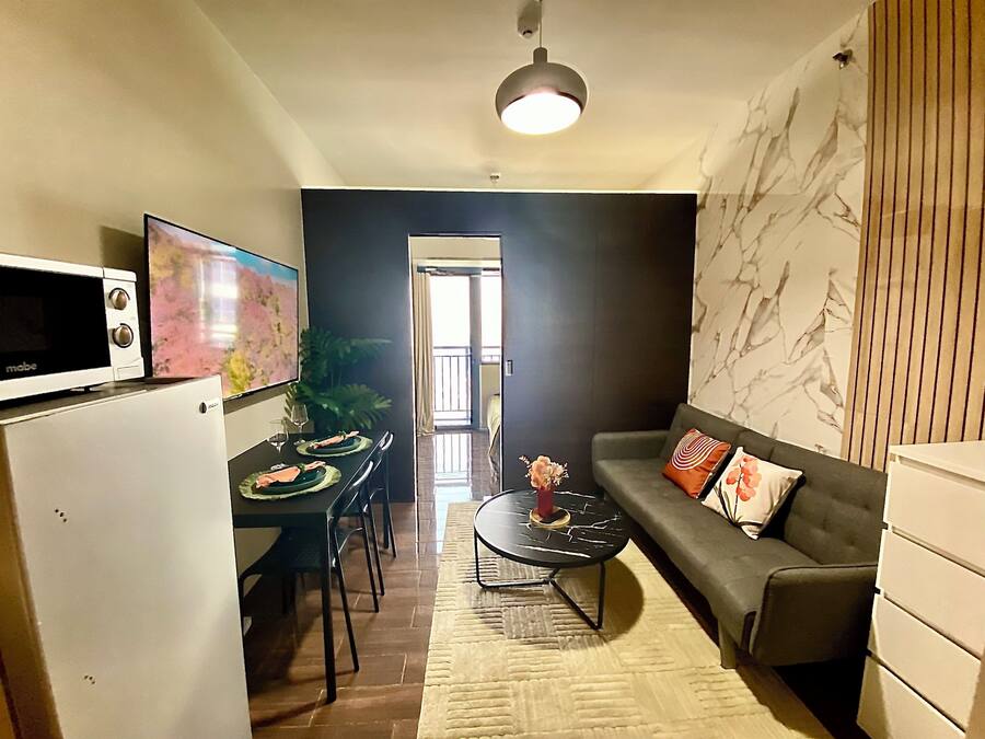 Un espace de vie compact comprenant une kitchenette, un coin repas et un coin salon.