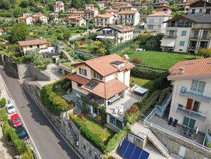 A residential area with houses, a road, and a person walking. - Villa Comacina, Como Lake (Ossuccio)