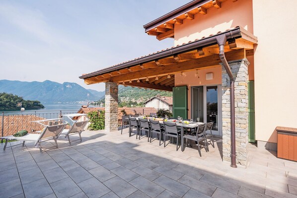 An outdoor dining area with a view of mountains and a lake. - Villa Comacina, Como Lake (Ossuccio)