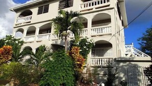 A multi-story building with balconies and a central courtyard. - Bananaquit House (Frederiksted)
