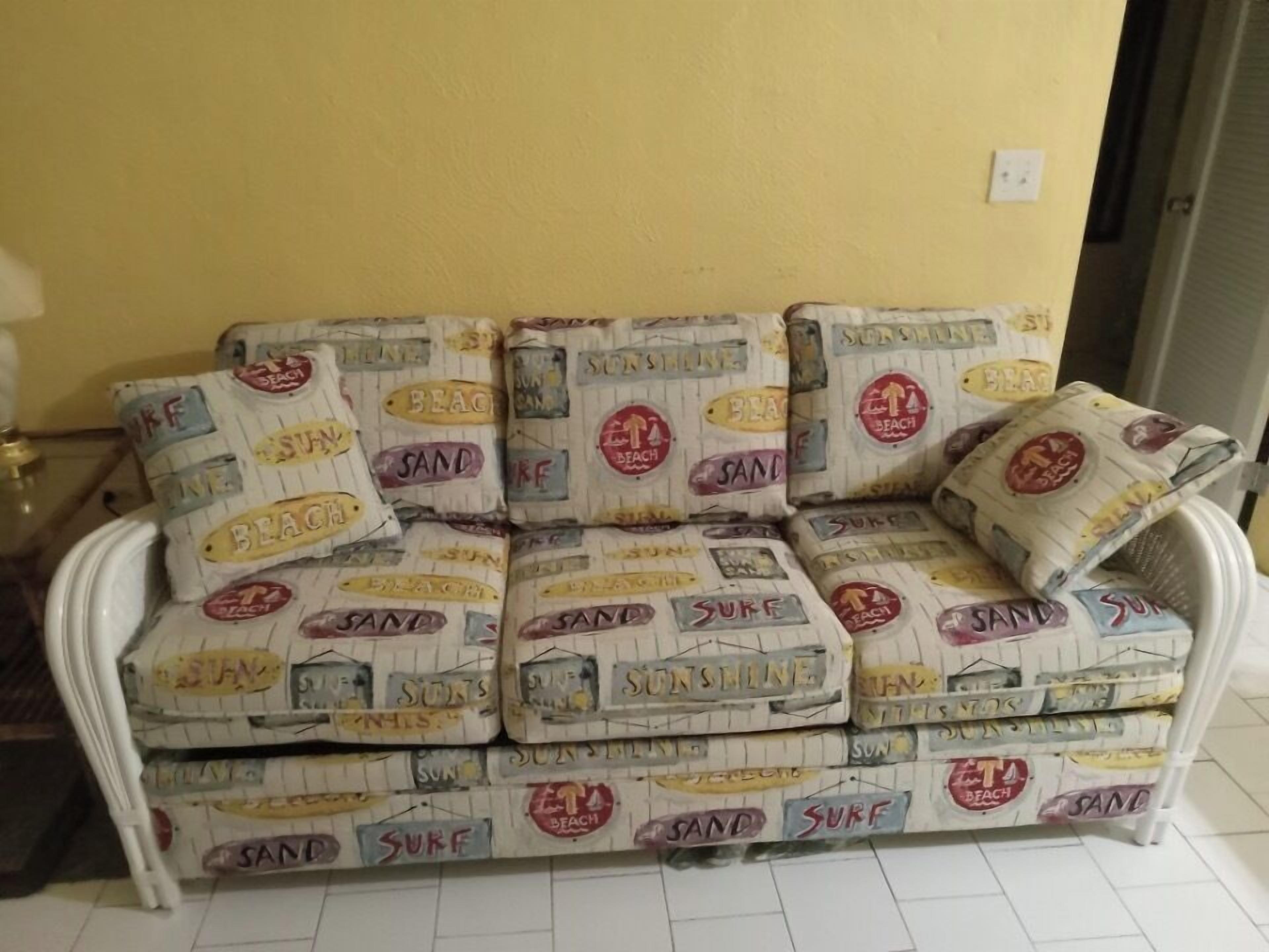 A sofa with a beach-themed fabric pattern.