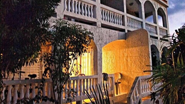 A multi-story building with balconies and a staircase. - Bananaquit House (Frederiksted)