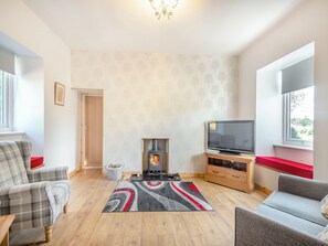 A living room with a fireplace, a television, and two sofas. - 1 bedroom accommodation in Pinwherry, near Girvan (Pinwherry, near Girvan)