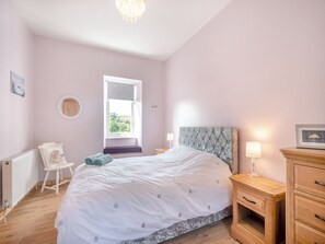 A bedroom with a bed, a bedside table with a lamp, a chair, a radiator, and a window with a view. - 1 bedroom accommodation in Pinwherry, near Girvan (Pinwherry, near Girvan)