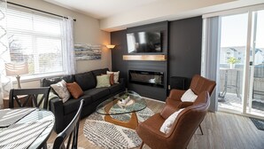 Una sala moderna con una mesa de centro de vidrio, un sofá y una chimenea.