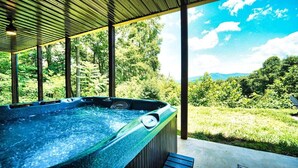 A hot tub with a view of a lush green landscape and mountains in the distance. - Meribel-Hot tub-Fire pit-Amazing Views (Young Harris)