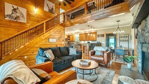 A spacious living area with a staircase, a kitchen, and a fireplace. - Meribel-Hot tub-Fire pit-Amazing Views (Young Harris)