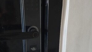 A black door with a keyhole and a fingerprint scanner.