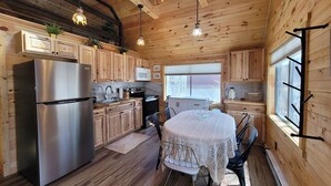 Una cocina moderna con armarios de madera, electrodomésticos de acero inoxidable y un comedor con mantel de encaje.
