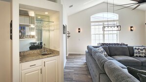 A modern kitchen with a granite countertop, a large mirror, and a built-in sink. - Five Star 3bd Waterfront Canal Home w/ Private Pool/Spa & Boat Dock. (Palm Coast)