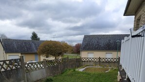 A residential area with a grassy yard, a wooden fence, and houses with sloped roofs.