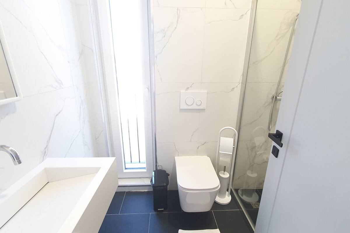 deluxe room | bathroom | shower, rainfall showerhead, hair dryer, slippers