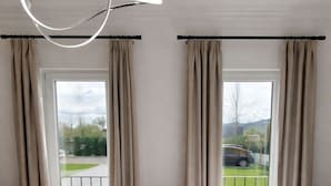 Une chambre d’hôtel avec deux lits, une vue sur un paysage verdoyant et un balcon.