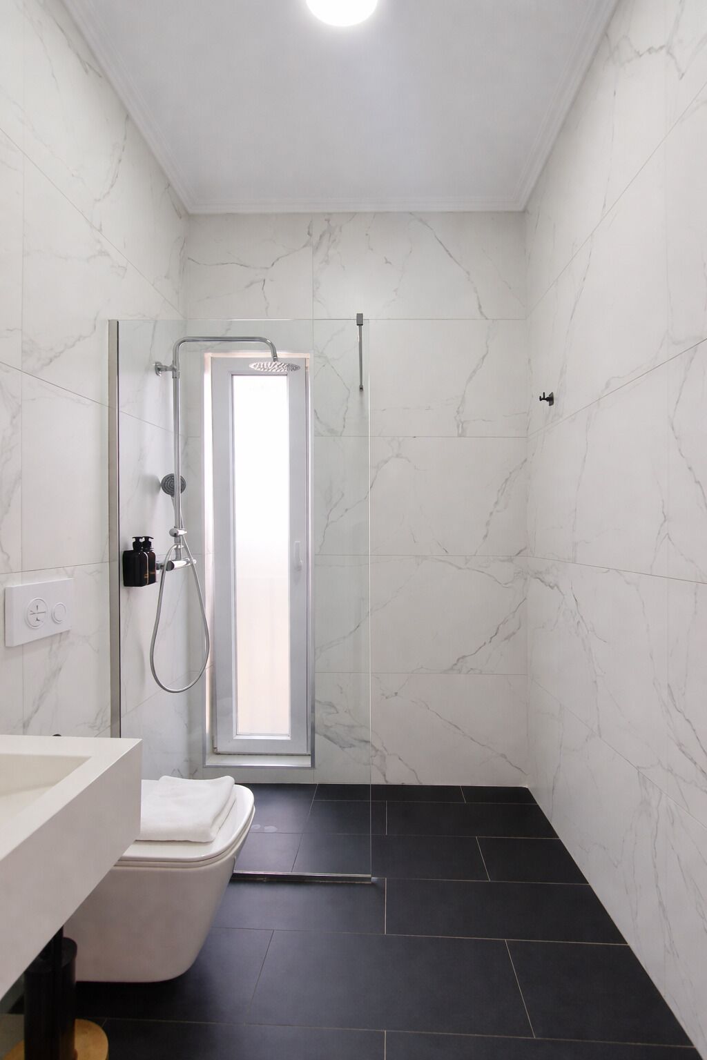 A bathroom with a shower, toilet, and sink.