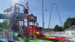 Une attraction aquatique sur le thème des pirates, comprenant une structure représentant un navire échoué et un toboggan.