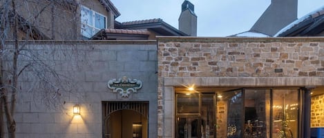 A building with a stone facade, a sign reading 'Le Chamonix,' and a glass entrance.
