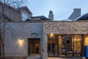 A building with a stone facade, a sign reading 'Le Chamonix,' and a glass entrance.