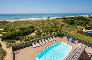 A pool area with lounge chairs and a view of the beach. - 8BR OCEAN/BEACHFRONT w/ HEATED POOL & HOT TUB in OBX! (Frisco)