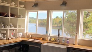 Keittiössä on puuhyllyt, pesuallas ja ikkunat, joista avautuu näkymä järvelle.