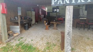 Una casa rural tipo granero con un letrero que dice "BARNHOUSE PANTRY" y "DRINKS & SNACKS".