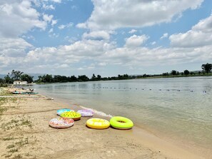 A beach with several colorful inflatable rings and a calm lake in the background. - Hot Tub Cozy Cottage in Colorado Springs (Colorado Springs)