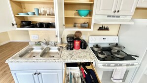 Une cuisine compacte équipée de deux éviers, d’une machine à café, d’un grille-pain et d’une cuisinière.