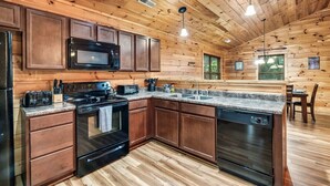A kitchen with wooden cabinets, a microwave, stove, and dishwasher. - Free Dollywood Tix/Pool/5Min2Dollywood/Pool Table (PIgeon Forge)