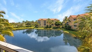 Ein Resort mit großem, spiegelndem Pool, mehreren Gebäuden mit roten Dächern und Palmen.