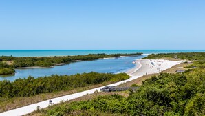 Un paisaje costero con playa, una vía fluvial y una carretera que lleva a la playa.