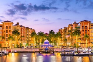 A waterfront hotel with multiple buildings, a central gazebo, and a marina with boats.