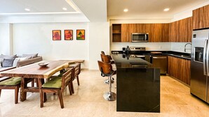 Una cocina moderna con armarios de madera, una isla central y electrodomésticos de acero inoxidable.