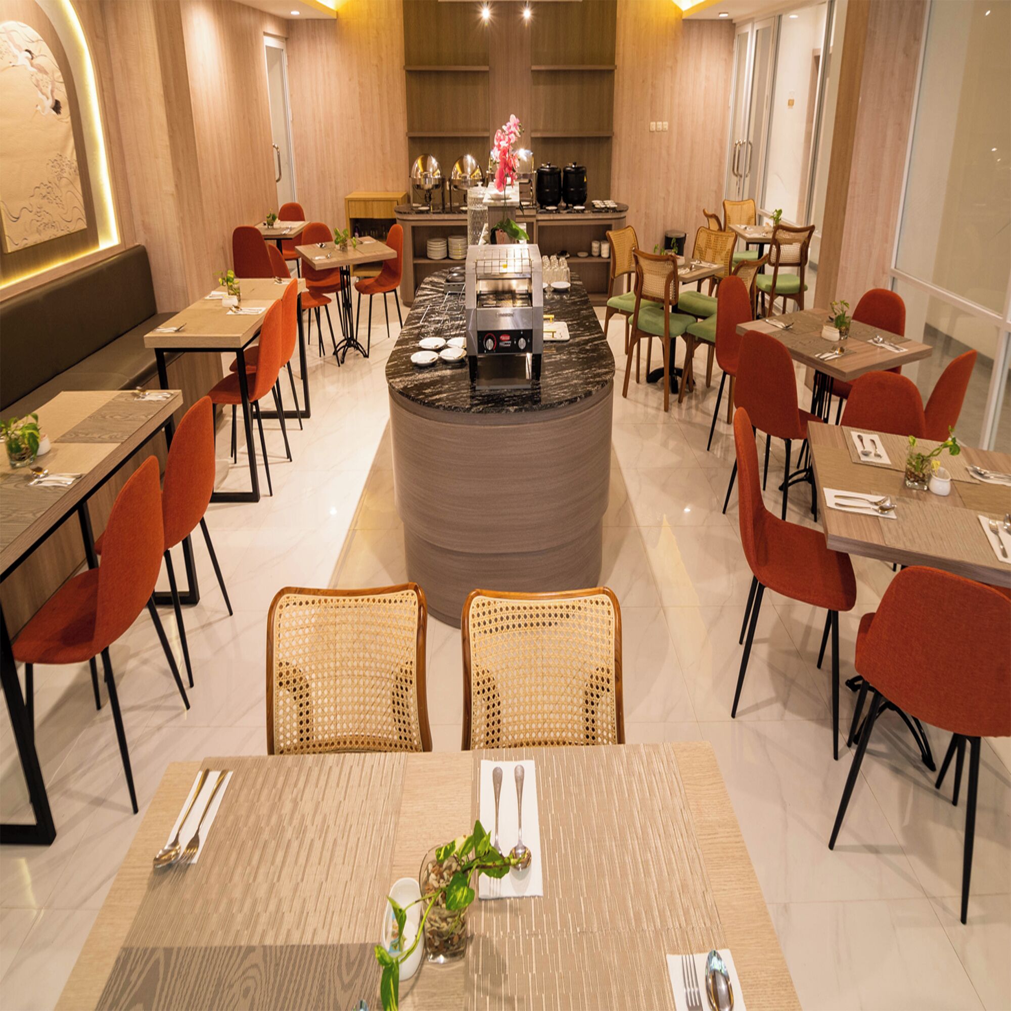 A modern restaurant with a central bar, multiple dining tables, and chairs.