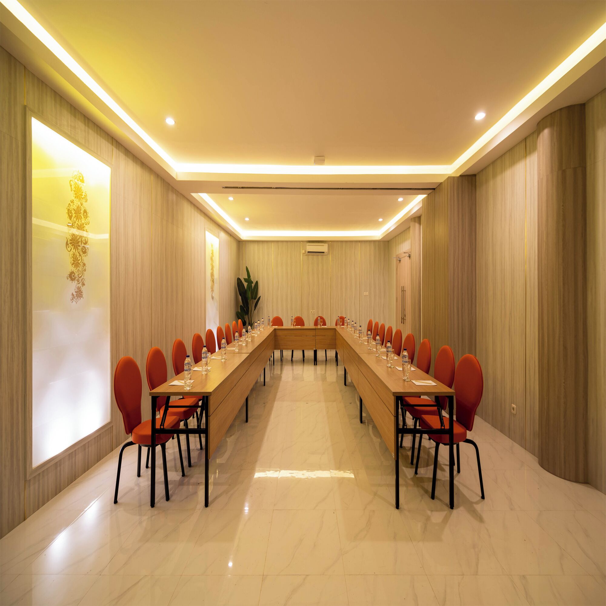 Une salle de conférence dotée d’une longue table, de chaises rouges et d’un design moderne.