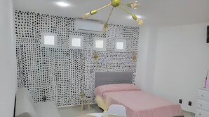 Ein Schlafzimmer mit einem Bett, einem Schreibtisch, einem Stuhl und einem Tisch.