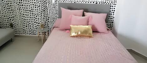 A bedroom with a bed, a small round table, and a sofa.
