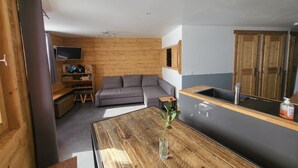 A modern kitchen with wooden cabinetry, a built-in oven, and a sink.