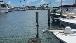 Un puerto deportivo con barcos amarrados, postes de madera y una bandera estadounidense.